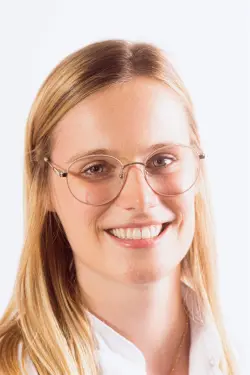 Portretfoto van Isaline Neirynck, tandartsassistente, blond en met bril.