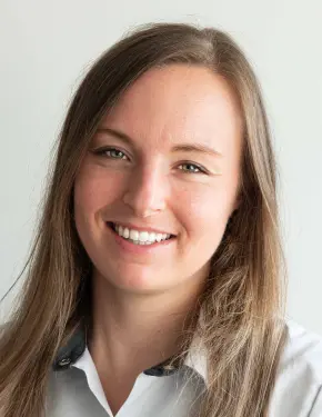 Portretfoto van Jolien Catrysse, algemeen tandarts, lachend in een wit uniform.
