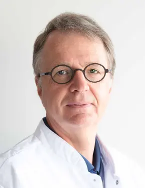 Portretfoto van Stefan Billiouw, specialist orthodontie, in een wit doktersjasje.